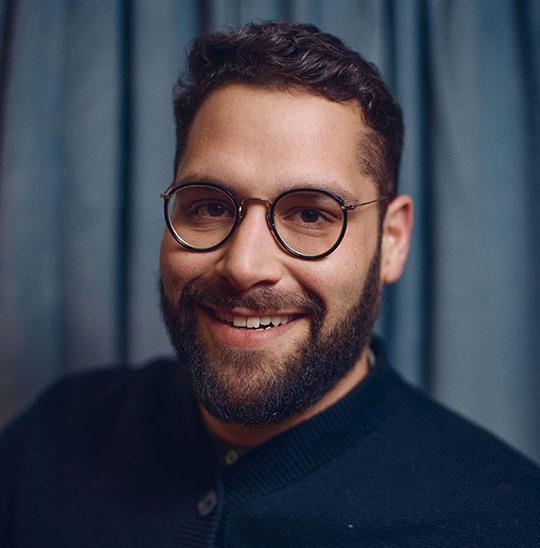 headshot of smiling man with glasses